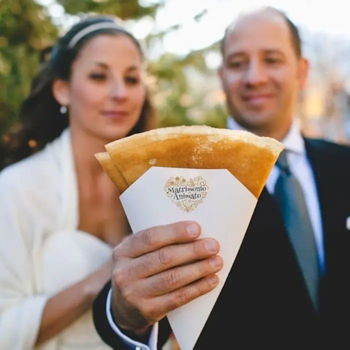 Couple enjoying a crêpe at their wedding