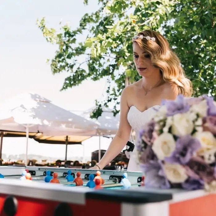 Bride playing foosball at a wedding