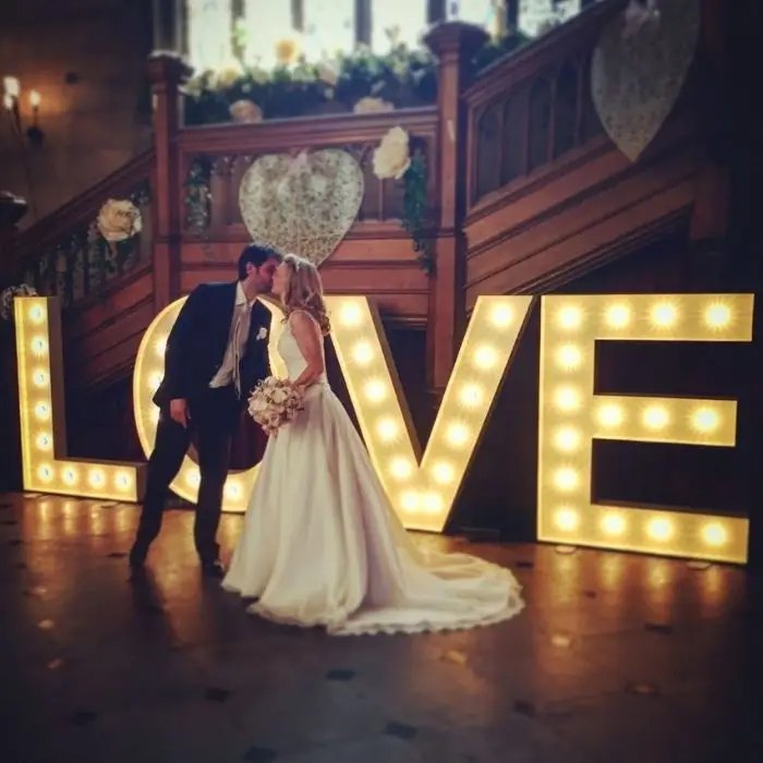 Couple with light-up LOVE letters at their wedding