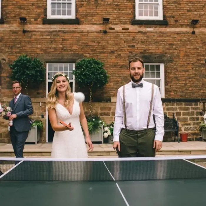 Couple playing ping pong at their wedding